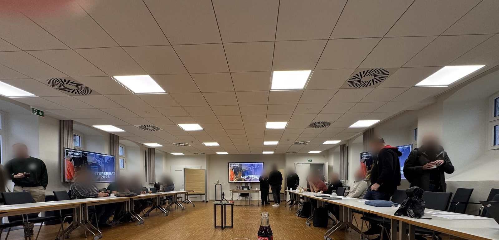 Tagungsraum beim mittwald Agenturbeirat 2026 mit Bildschirmen „Agenturbeirat 2026“, Teilnehmende unkenntlich gemacht